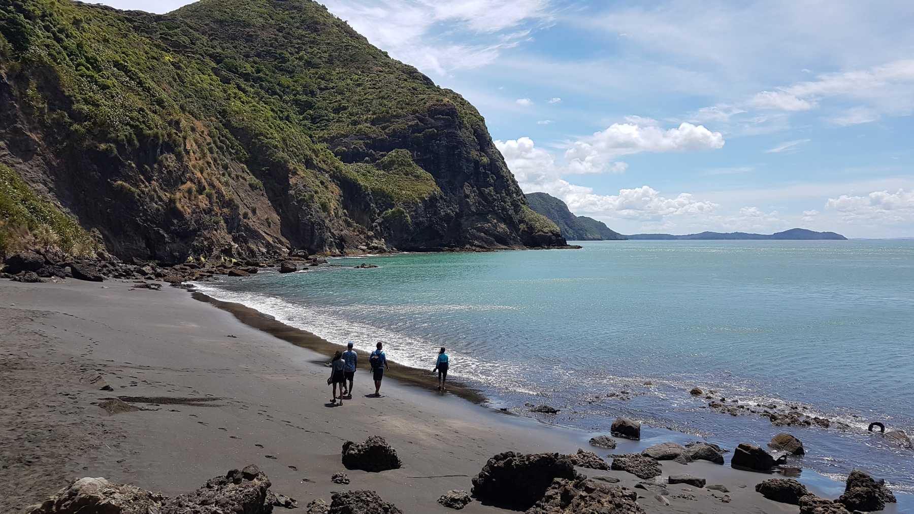 Surf the dramatic black sand of Piha